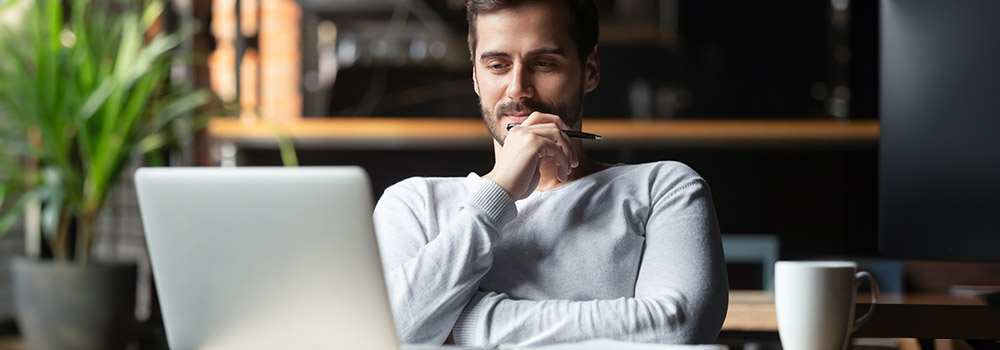 Student arbeitet nachdenklich am Laptop